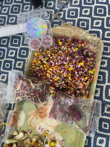 A collection of colourful dried flowers and herbs in a decorative tray.
