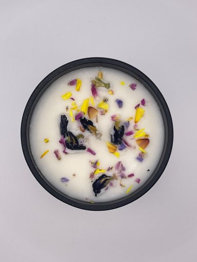 Top view of candle in black jar with dried flowers
