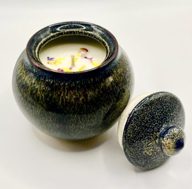 Ceramic jar with candle and dried flowers