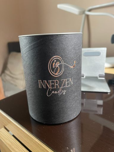 Black round box with "Inner Zen" logo on a wooden table.