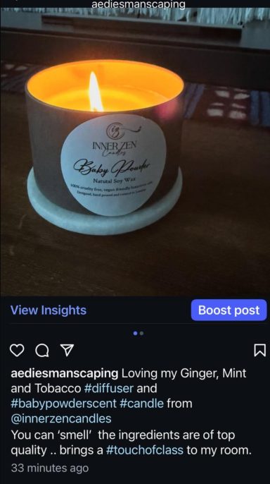A lit candle in a small holder, glowing warmly against a dark background.