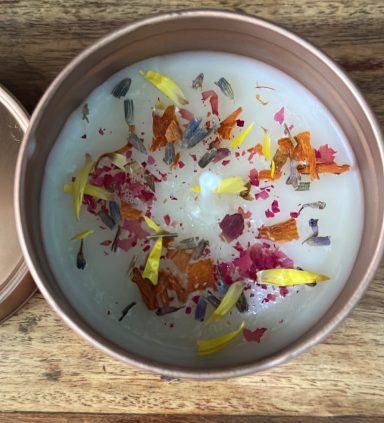 Top view of a set candle with dried flowers in a gold tin
